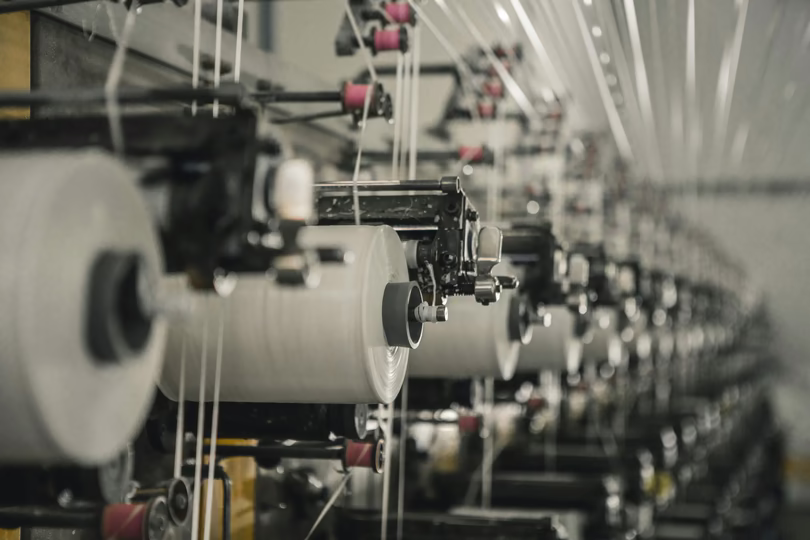 Textile mill production line with yarn spools